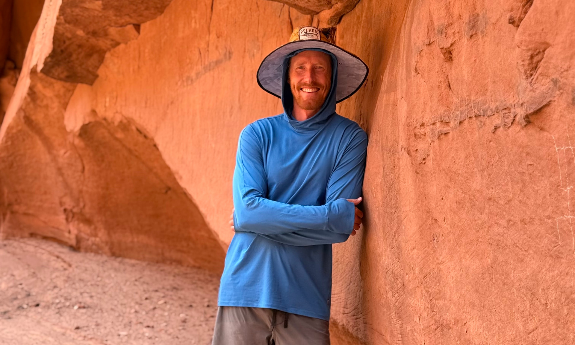 Nate Langley leaning against a red rock canyon wall in Sedona